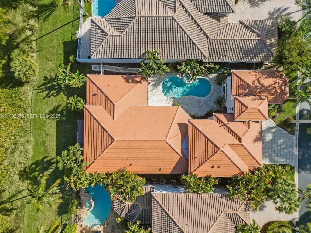 Aerial drone view of luxury Florida townhomes featuring pristine concrete tile roofs and swimming pools